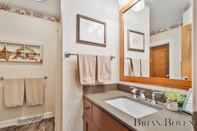 2625 Elmwood Dr, Pierson, MI 49339 - full bath with vanity, wood finished floors, and wallpapered walls