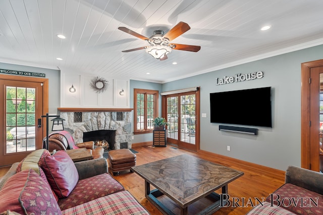 2625 Elmwood Dr, Pierson, MI 49339 - living area with a stone fireplace, a ceiling fan, recessed lighting, light wood-type flooring, and crown molding