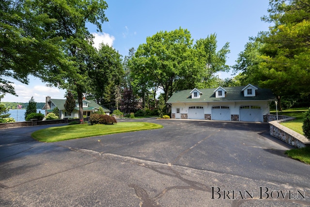 2625 Elmwood Dr, Pierson, MI 49339 - cape cod-style house featuring stone siding, a garage, and a front yard