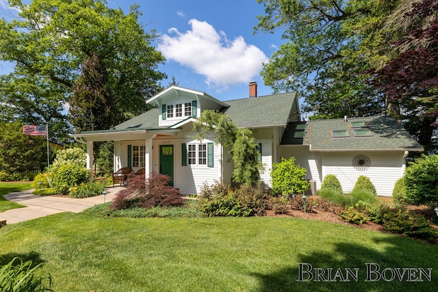 2625 Elmwood Dr, Pierson, MI 49339 - view of front of house with a front yard, a chimney, and roof with shingles