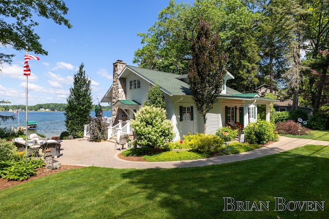 2625 Elmwood Dr, Pierson, MI 49339 - view of side of property with a yard, a chimney, and a water view