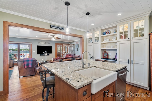 2625 Elmwood Dr, Pierson, MI 49339 - kitchen featuring ornamental molding, open shelves, pendant lighting, glass insert cabinets, and wood-type flooring