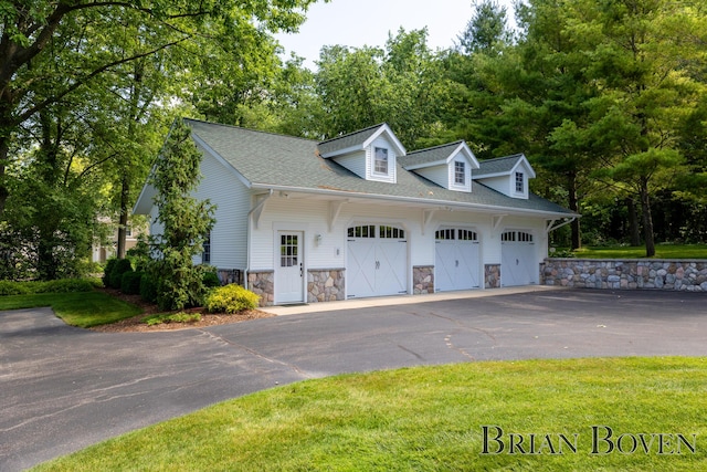 2625 Elmwood Dr, Pierson, MI 49339 - view of front facade featuring an attached garage, asphalt driveway, stone siding, roof with shingles, and a front lawn