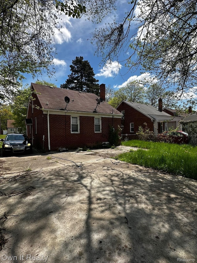 19505 Sunderland Rd, Detroit, MI 48219 - view of property exterior featuring brick siding and a chimney