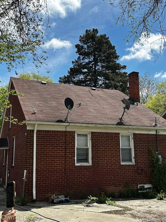 19505 Sunderland Rd, Detroit, MI 48219 - view of property exterior with brick siding, a chimney, and a shingled roof