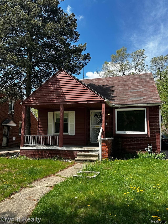 19505 Sunderland Rd, Detroit, MI 48219 - bungalow with covered porch, brick siding, a front lawn, and a shingled roof
