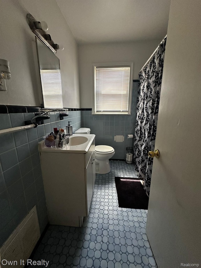 19505 Sunderland Rd, Detroit, MI 48219 - bathroom with vanity, tile walls, wainscoting, curtained shower, and tile patterned floors