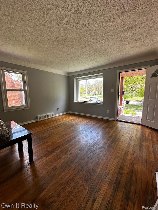19505 Sunderland Rd, Detroit, MI 48219 - unfurnished living room with dark wood-style flooring and a textured ceiling
