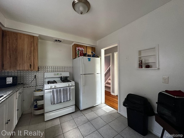 19505 Sunderland Rd, Detroit, MI 48219 - kitchen with white appliances, light tile patterned floors, backsplash, and brown cabinetry