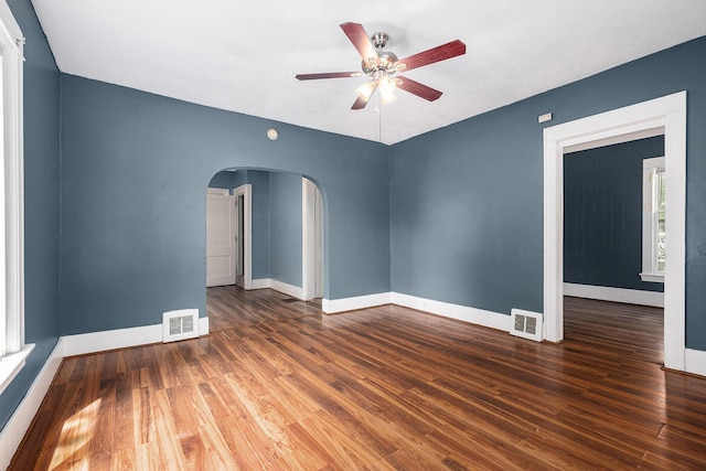 863 Burton St SE, Grand Rapids, MI 49507 - unfurnished room with arched walkways, a ceiling fan, and wood finished floors