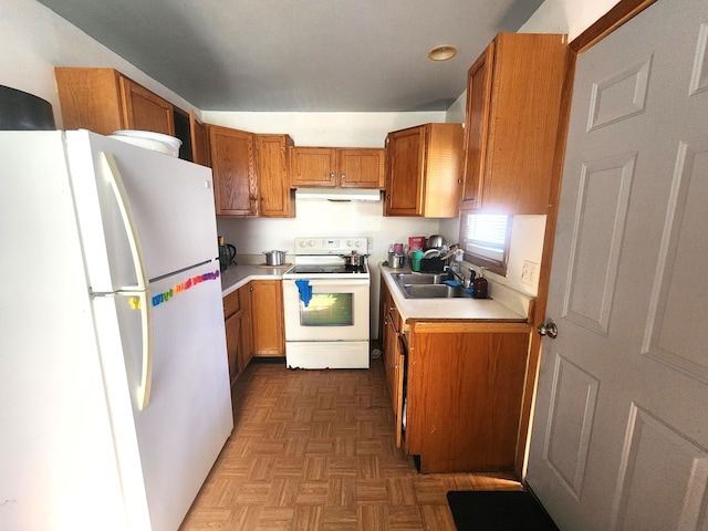 2258 Mckee Ave SW, Grand Rapids, MI 49503 - kitchen with white appliances, under cabinet range hood, brown cabinets, and light countertops