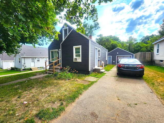 2258 Mckee Ave SW, Grand Rapids, MI 49503 - view of front of house with entry steps, a garage, a chimney, driveway, and an outbuilding
