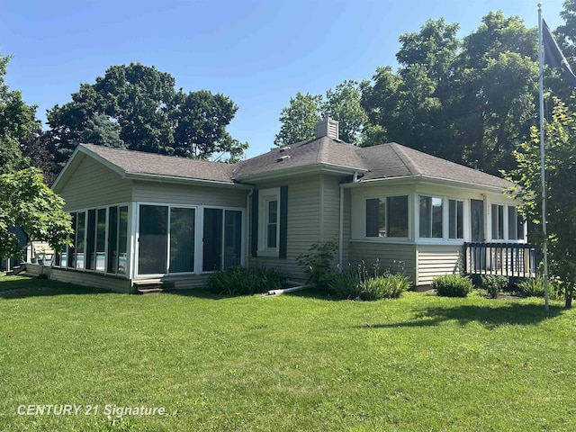 324 Pine St, Clio, MI 48420 - back of house featuring a sunroom, a lawn, a chimney, and a shingled roof