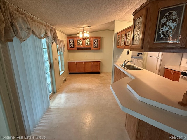 26852 Roric St, Novi, MI 48377 - kitchen featuring a textured ceiling, a chandelier, brown cabinetry, light countertops, and freestanding refrigerator