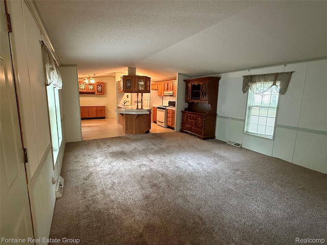 26852 Roric St, Novi, MI 48377 - unfurnished living room with a chandelier, light colored carpet, lofted ceiling, and a textured ceiling