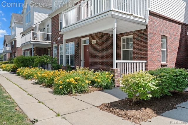 8461 Towne Center Cir N, Warren, MI 48093 - property entrance with a balcony, brick siding, and a porch