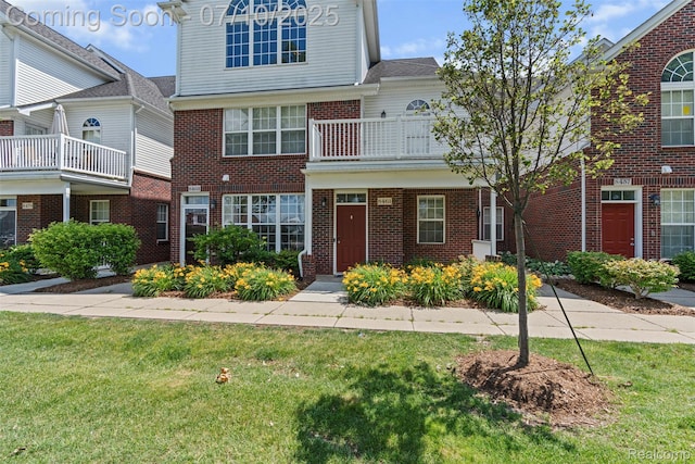8461 Towne Center Cir N, Warren, MI 48093 - view of property with a front lawn, brick siding, and a balcony