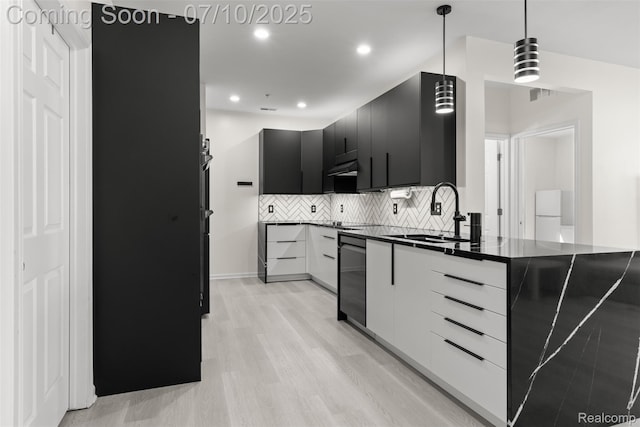 8461 Towne Center Cir N, Warren, MI 48093 - kitchen featuring dark cabinetry, dark countertops, light wood-style flooring, backsplash, and pendant lighting
