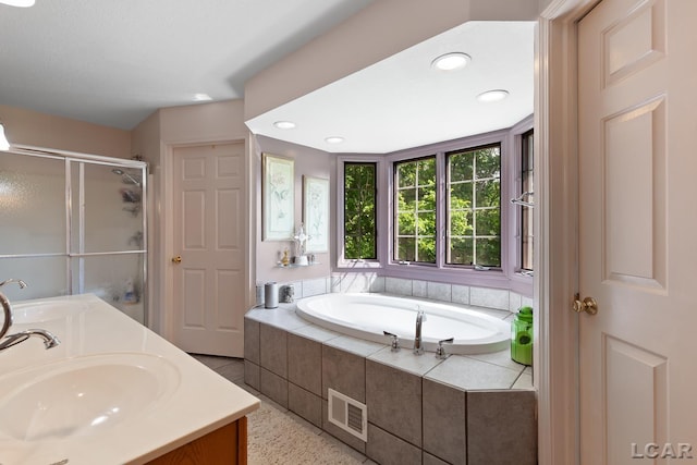 15858 Lelah Ln, Addison, MI 49220 - bathroom featuring a garden tub, a shower stall, double vanity, and recessed lighting