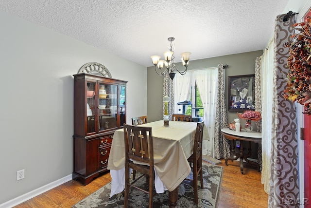 15858 Lelah Ln, Addison, MI 49220 - dining area featuring a chandelier, light wood finished floors, and a textured ceiling
