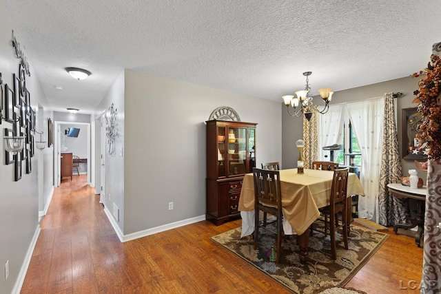 15858 Lelah Ln, Addison, MI 49220 - dining room featuring a chandelier, wood finished floors, and a textured ceiling