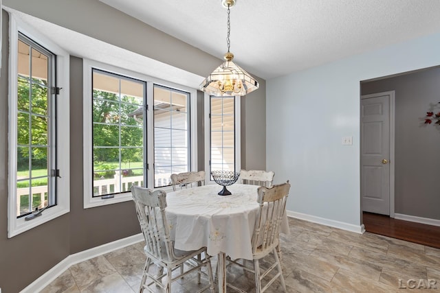 15858 Lelah Ln, Addison, MI 49220 - dining area featuring a textured ceiling, light stone finish floors, and a chandelier
