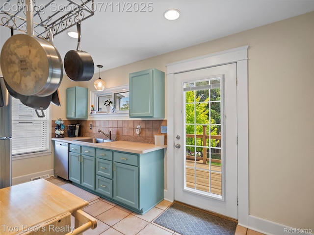 30 Beebe St, Lake Orion, MI 48362 - kitchen featuring stainless steel dishwasher, light countertops, decorative backsplash, light tile patterned flooring, and hanging light fixtures