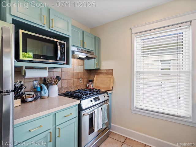 30 Beebe St, Lake Orion, MI 48362 - kitchen with stainless steel appliances, under cabinet range hood, tasteful backsplash, light countertops, and light tile patterned floors