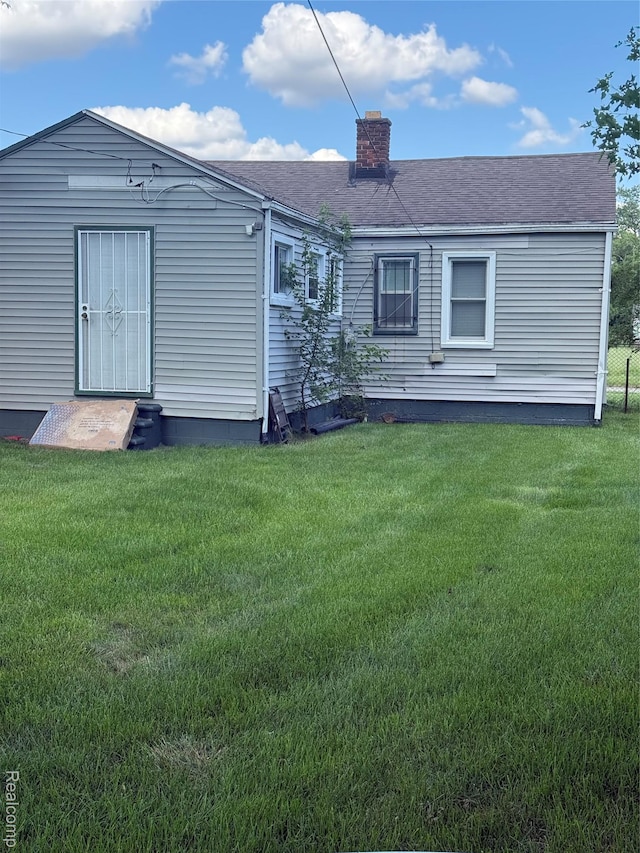 19361 Lindsay St, Detroit, MI 48235 - rear view of house with a chimney, a yard, entry steps, and a shingled roof