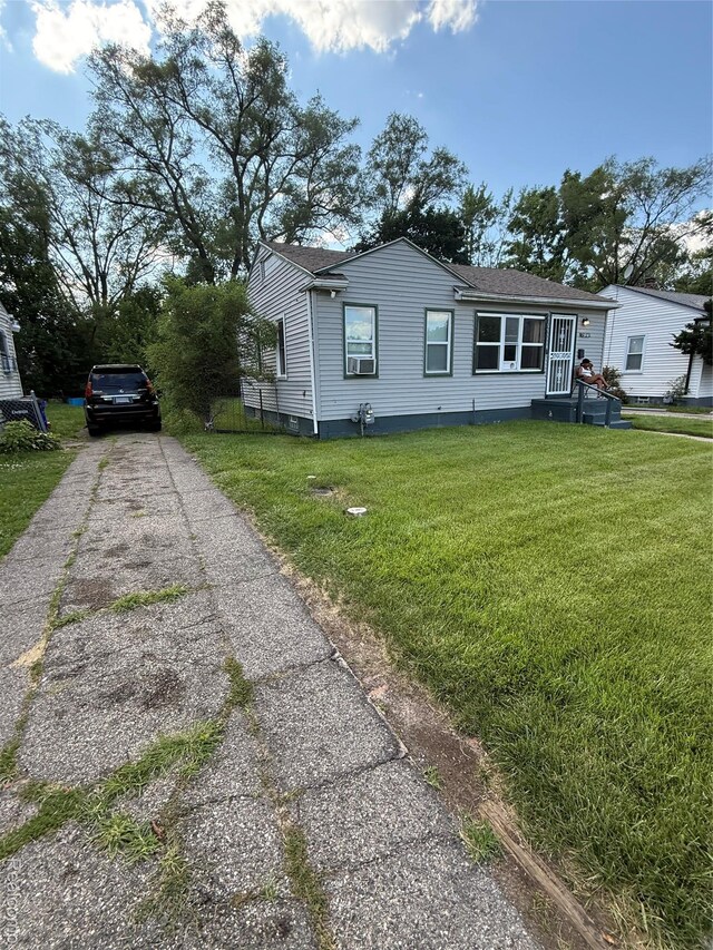 19361 Lindsay St, Detroit, MI 48235 - view of front of house featuring a front yard, asphalt driveway, cooling unit, and a shingled roof