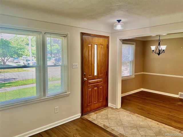 1992 Griffith Ave, Berkley, MI 48072 - foyer entrance featuring healthy amount of natural light, a chandelier, light tile patterned floors, and a textured ceiling
