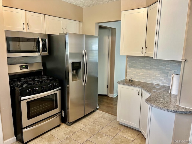 1992 Griffith Ave, Berkley, MI 48072 - kitchen with stainless steel appliances, white cabinetry, backsplash, and a textured ceiling
