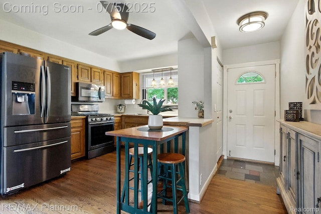 11634 Spicer Dr, Plymouth, MI 48170 - kitchen featuring stainless steel appliances, brown cabinets, light countertops, ceiling fan, and dark wood finished floors