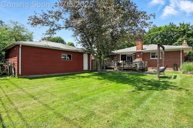 11634 Spicer Dr, Plymouth, MI 48170 - rear view of property with a chimney, a yard, a wooden deck, and brick siding