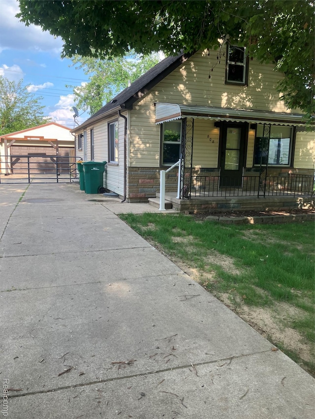 808 Lamay Ave, Ypsilanti, MI 48198 - bungalow-style home featuring a porch, an outdoor structure, and a detached garage