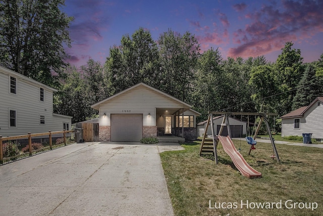 1003 Kusterer Dr NW, Grand Rapids, MI 49534 - view of front of house featuring concrete driveway, an attached garage, brick siding, and a playground
