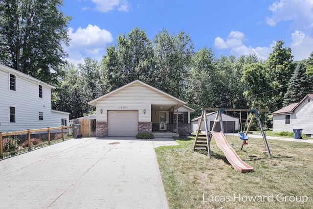 1003 Kusterer Dr NW, Grand Rapids, MI 49534 - view of front of home featuring driveway, covered porch, brick siding, a playground, and a garage