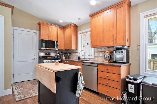 1003 Kusterer Dr NW, Grand Rapids, MI 49534 - kitchen featuring stainless steel appliances, wooden counters, tasteful backsplash, wood finished floors, and recessed lighting