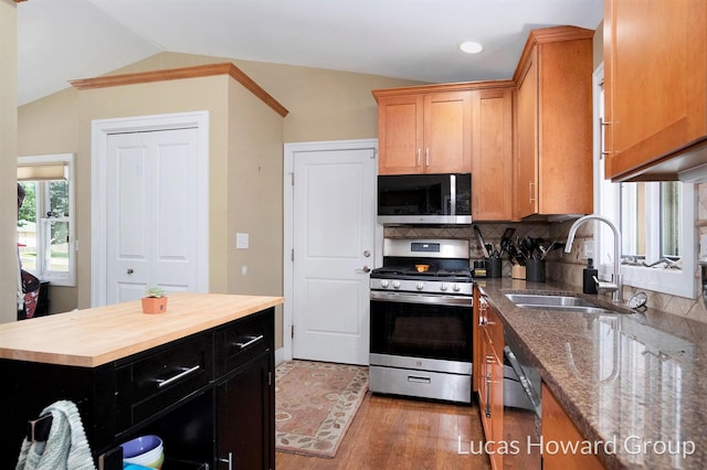 1003 Kusterer Dr NW, Grand Rapids, MI 49534 - kitchen featuring appliances with stainless steel finishes, butcher block countertops, wood finished floors, backsplash, and lofted ceiling