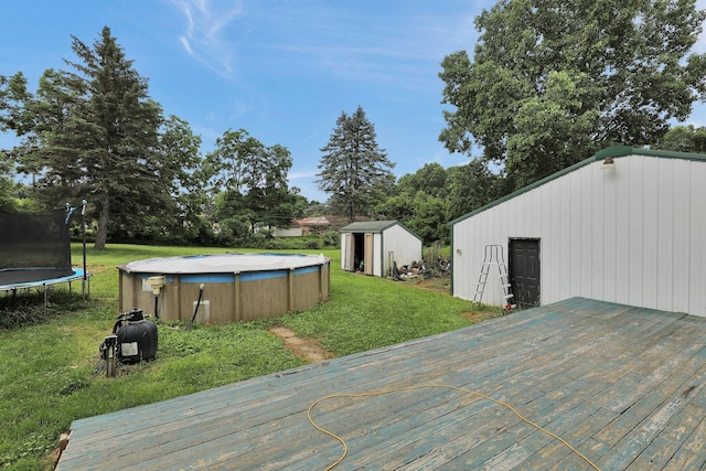 721 Foote St, Charlotte, MI 48813 - wooden terrace with a trampoline, a storage unit, a lawn, and an outdoor pool