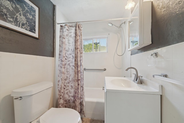 334 N Hickory St, Owosso, MI 48867 - full bathroom featuring tile walls, shower / tub combo with curtain, vanity, and a wainscoted wall