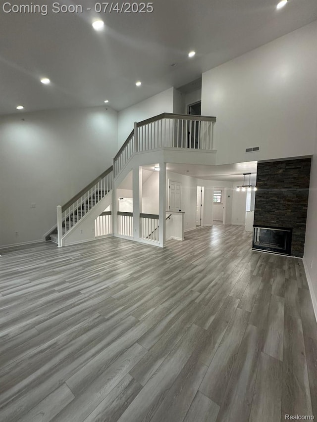 4248 Schaefer Rd, Dearborn, MI 48126 - unfurnished living room with stairs, a fireplace, wood finished floors, recessed lighting, and a high ceiling