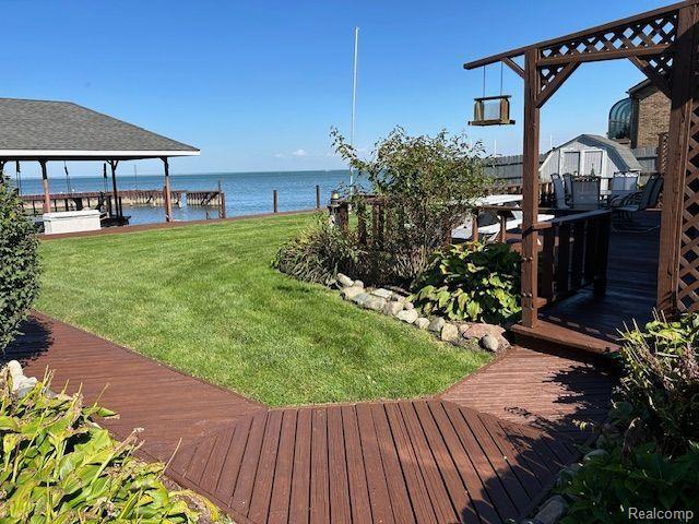 32241 N River Rd, Harrison Township, MI 48045 - view of grassy yard featuring a deck with water view and a boat dock