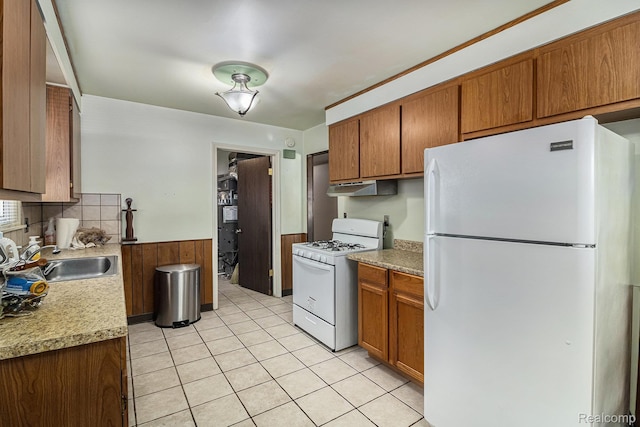 8476 Robindale Ave, Dearborn Heights, MI 48127 - kitchen with white appliances, under cabinet range hood, light countertops, a wainscoted wall, and brown cabinets