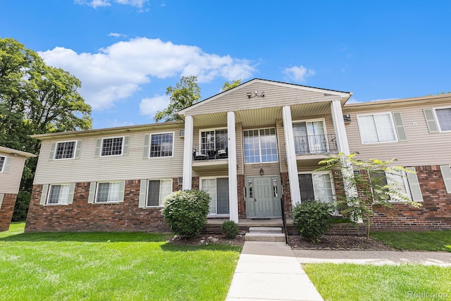 8150 24 Mile Rd, Shelby Twp, MI 48316 - view of front of house with a balcony, brick siding, and a front yard