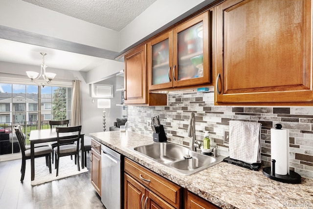 8150 24 Mile Rd, Shelby Twp, MI 48316 - kitchen with dishwasher, brown cabinetry, a chandelier, light countertops, and a textured ceiling