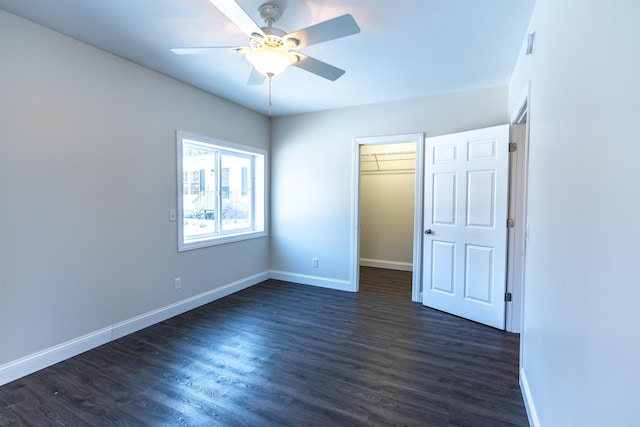 457 N Garfield, Traverse City, MI 49696 - unfurnished bedroom featuring dark wood-style flooring, a walk in closet, a closet, and ceiling fan