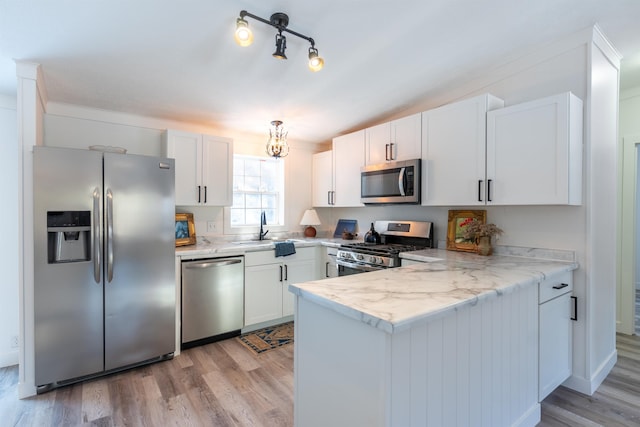 457 N Garfield, Traverse City, MI 49696 - kitchen featuring stainless steel appliances, a peninsula, light wood-style flooring, and white cabinetry