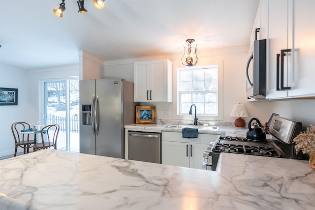 457 N Garfield, Traverse City, MI 49696 - kitchen with appliances with stainless steel finishes, a chandelier, healthy amount of natural light, and white cabinets
