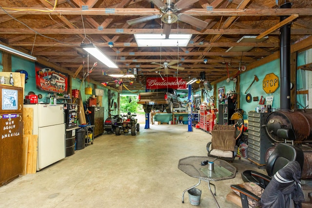 2314 Hand Rd, Niles, MI 49120 - garage featuring a workshop area, freestanding refrigerator, and a ceiling fan